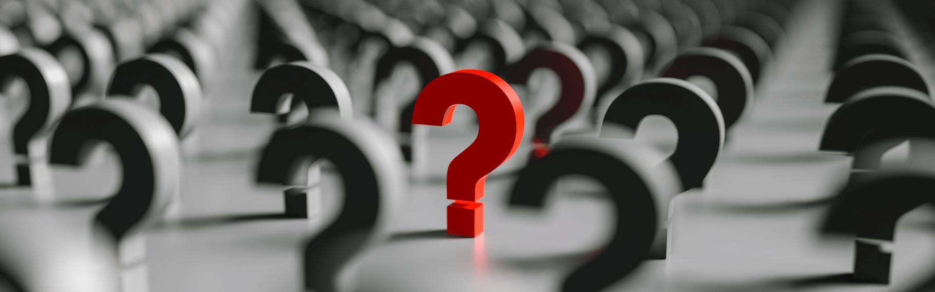 Group of black 3D question marks with one red question mark in the middle