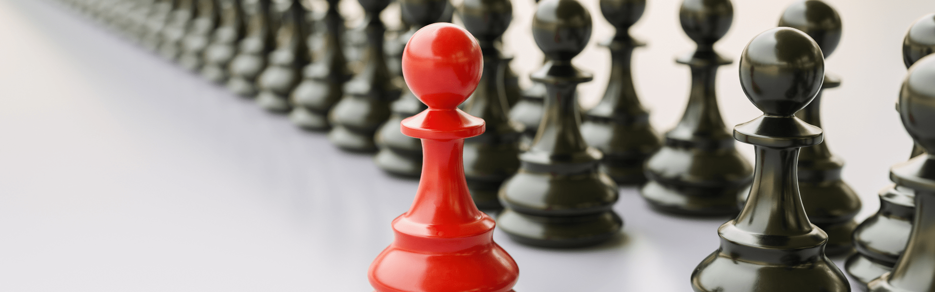 Collection of black pawns with one red pawn in front of them