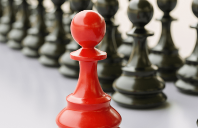 Collection of black pawns with one red pawn in front of them